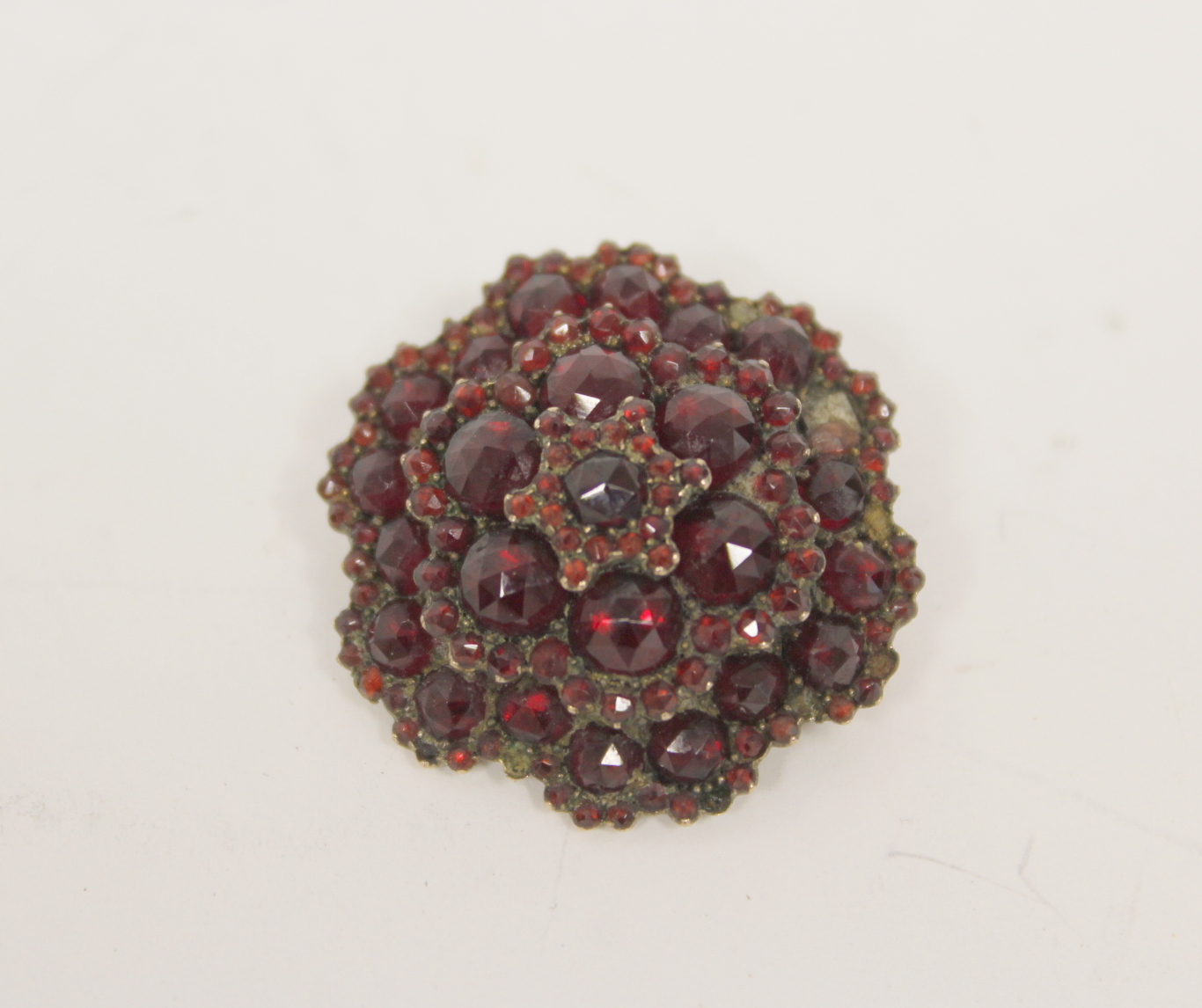 Victorian pyrope garnet hinged bangle in 'garnet' gold and a similar cluster brooch. (2). - Image 4 of 4