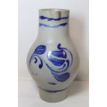 Grey stoneware jug of baluster form with painted stylised foliate decoration and banding in blue