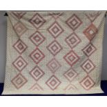 Later 19th/early 20th century quilt with log cabin diamond blocks in predominantly red and cream
