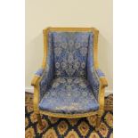 Early 20th century French upholstered wing back armchair raised on turned reeded supports