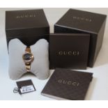 Gucci lady's stainless steel wristwatch with black dial, oval "G" bezel, on tapered bangle with