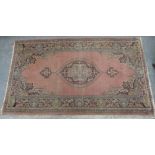 Eastern pink and green wool rug with floral medallion, 186cm x 109cm.