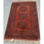 Small Persian wool red and black rug with three octagonal guls.