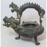 Chinese bronze wine kettle of circular squat form with a dragon spout and handle, three paw feet and