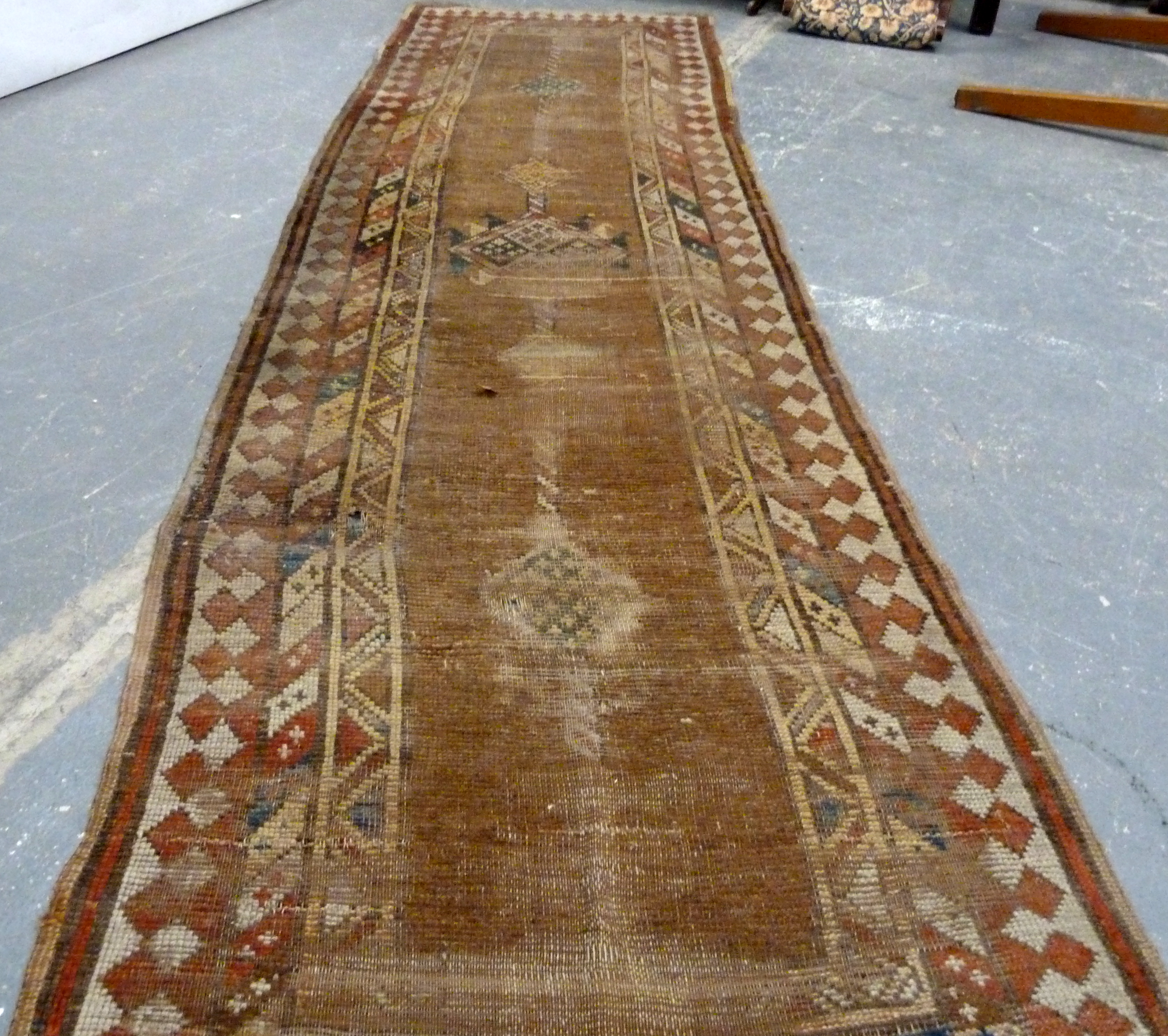 Turkish wool runner with geometric medallions and borders in muted palette, 285cm x 83cm, well worn.