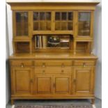 Oak Art Nouveau style dining room suite comprising a dresser the upper section enclosed by glazed