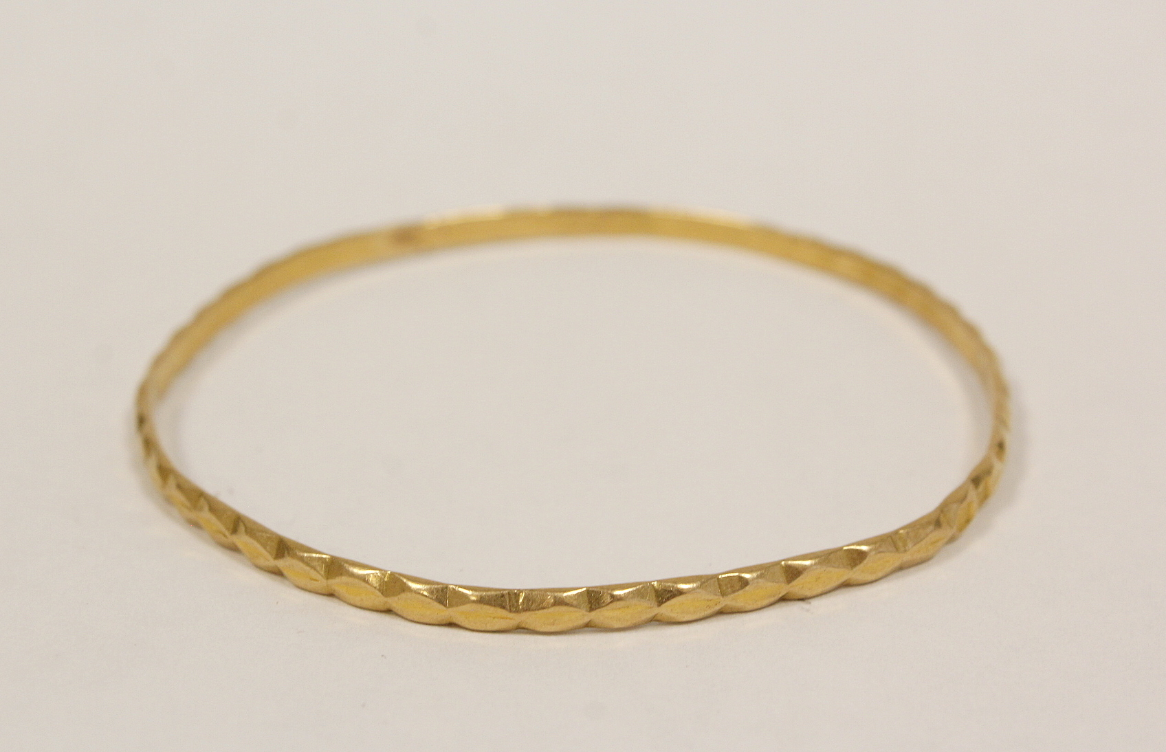 Gold slave bangle, probably Oriental 'fine' indistinctly marked, 13g.