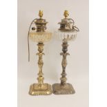 Near pair of similar oil lamps with silver foliate knopped stems on shaped square bases with foliate