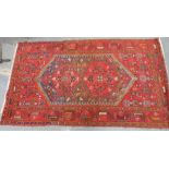 Persian wool carpet with double hexagonal medallions in hexagonal lozenge on red field, 213cm x