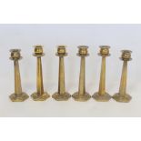 Set of four brass candlesticks, the globular sconces with circular drip trays on tapered hexagonal