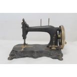 19th century black japanned manual sewing machine, no maker's name, the lobed plinth with four paw