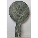 Antique Chinese bronze hand mirror of achaic form, the circular panel decorated with a deity and