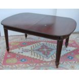 Mahogany extending dining table, the reeded rounded rectangular top enclosing an extra leaf, rosette