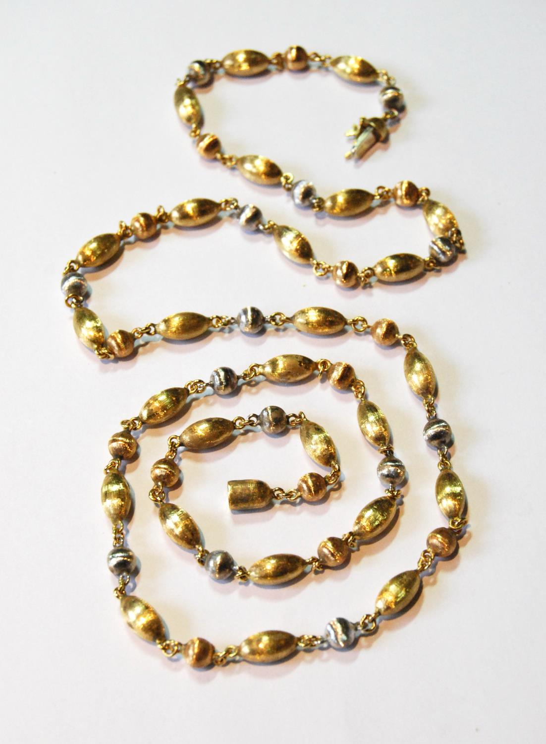 18ct coloured gold opera length necklace of textured oval and spherical beads, 31g.