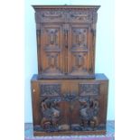 Carved oak cabinet, the projected cornice over panelled doors, on associated base with carved
