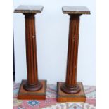 Pair of mahogany column stands, each with square marble top, ormolu floral mounts, tapering fluted