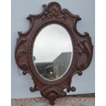 Large continental wall mirror with oval glass plate and floral carved frame, 120cm high and 89cm