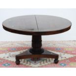 Regency rosewood and brass inlaid library table, the circular tilt top with floral brass inlay, on