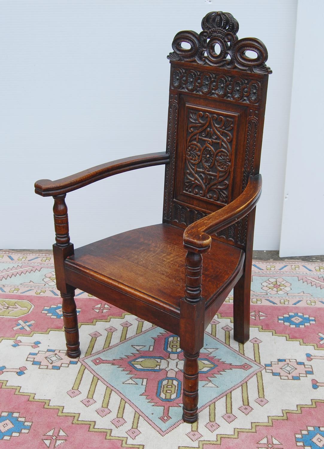 Jacobean-style oak throne chair, with crown carved finial over floral carved back panel, open