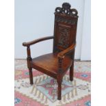 Jacobean-style oak throne chair, with crown carved finial over floral carved back panel, open