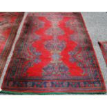 Turkoman carpet, the central opposing motifs over red ground and border, 235cm x 157cm.