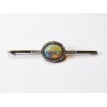 Victorian bar brooch with oval black/water opal surrounded and flanked by diamond brilliants in gold