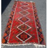 Persian long rug, the six diamonds with panel and rosettes over red ground and border, 330cm x