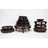 Eight oriental carved wooden stands.