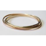 Three coloured 9ct gold slave bangles of Russian style, 37g.