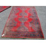 Turkoman carpet, the central opposing motifs over red ground and border, 232cm x 159cm.