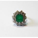 Diamond and emerald oval cluster ring with rectangular emerald and twenty diamond brilliants in