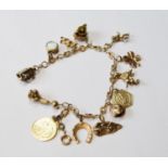 Gold bracelet with South African half pond and various other charms, mostly gold, 36g gross.