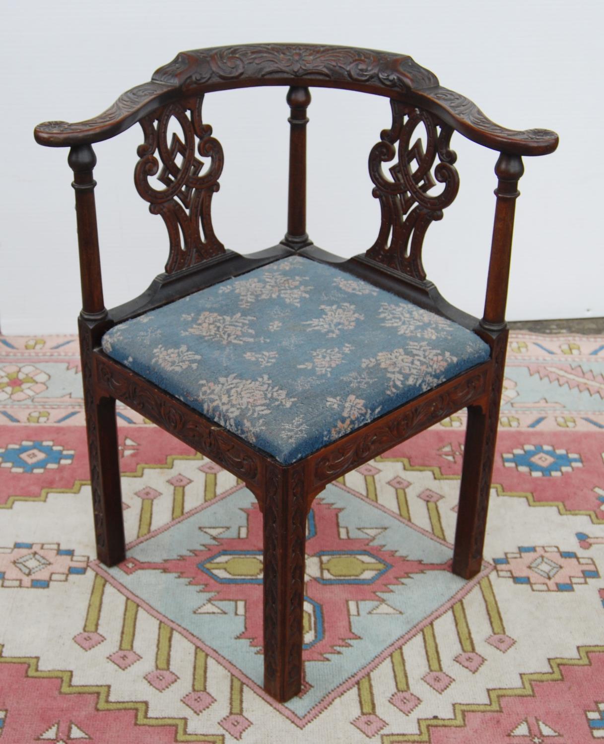 Mahogany carved corner chair, the stepped serpentine top rail over baluster and interlaced splats,