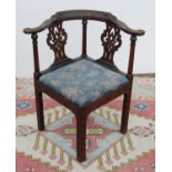 Mahogany carved corner chair, the stepped serpentine top rail over baluster and interlaced splats,