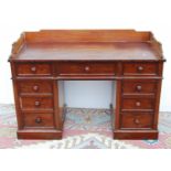 Mahogany kneehole desk with three-quarter gallery, the rectangular top over frieze drawer flanked by