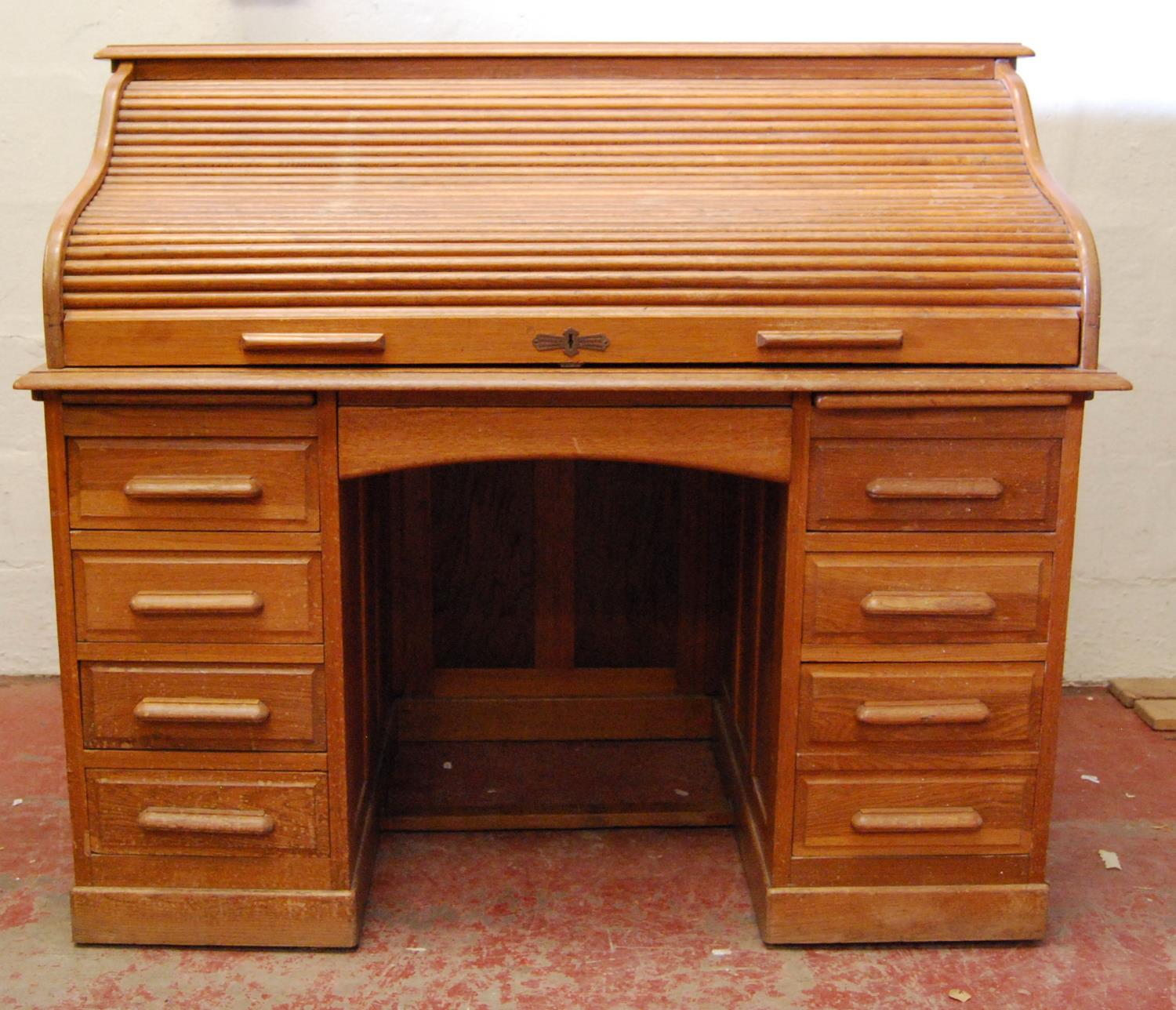 Oak roll-top desk, the tambour front enclosing a fitted interior, kneehole drawer flanked by banks