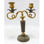 Neoclassical gilt metal candlestick with opposing scrolling serpentine branches terminating in