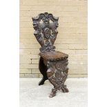 19th century oak hall chair, profusely pierced & carved, the back flanked by mermaid grotesque