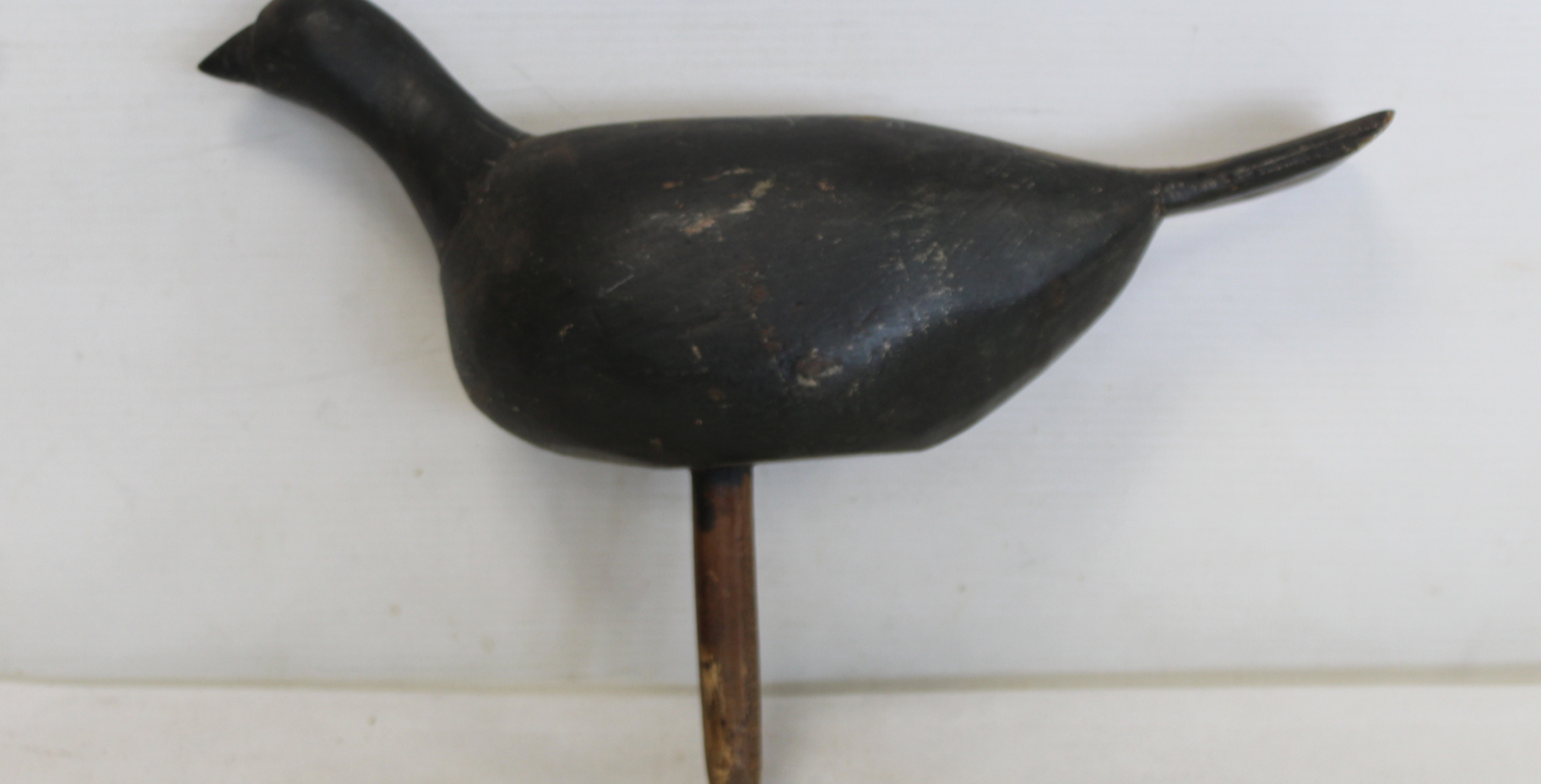 Antique wooden bird decoy with grey painted finish and peg base, 23.5cm high and 31cm long.