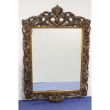 Antique mahogany wall mirror the pierced foliate frame with crowned cherub surmount. 124 cm high