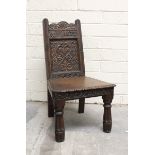 Antique carved oak low chair, the back bearing the date 1677, with solid seat on turned fluted