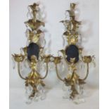 Pair of 20th century gilt metal girandoles with twin sconces, oval mirrors, floral and foliate