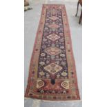 Large red and blue Persian runner with six hooked diamond medallions and octagonal guls. 371cm x