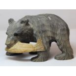 Japanese Ainu wood carving of a bear carrying a large fish, stained decoration, 9cm high.