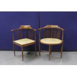 Two mahogany corner chairs with reeded stick back supports and satinwood inlaid banding, on columnal