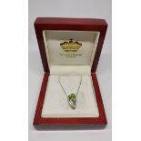 9ct white gold drop pendant with large central triangle cut peridot flanked by two diamonds on 9ct