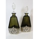 Pair of olive green cut glass decanters of tapering shape with silver pierced and engraved holders,