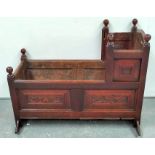 Antique oak cradle, the foliate scroll and stylised flowerhead carved panels with turned knops and