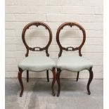 Pair of Victorian carved balloon back side chairs, over upholstered seats, on cabriole supports.