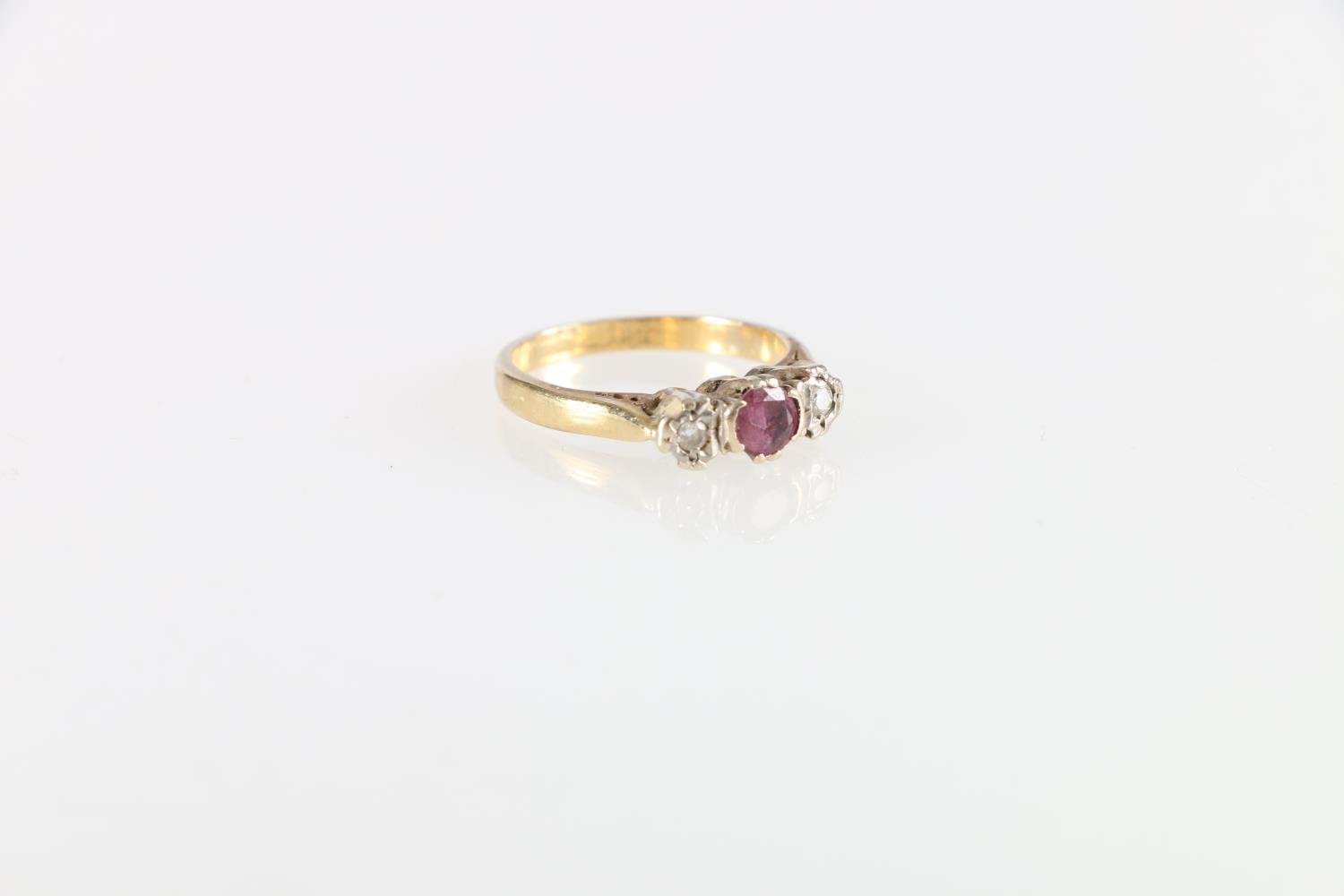 Unhallmarked yellow metal ruby and diamond three stone ring, size K, 3.2g